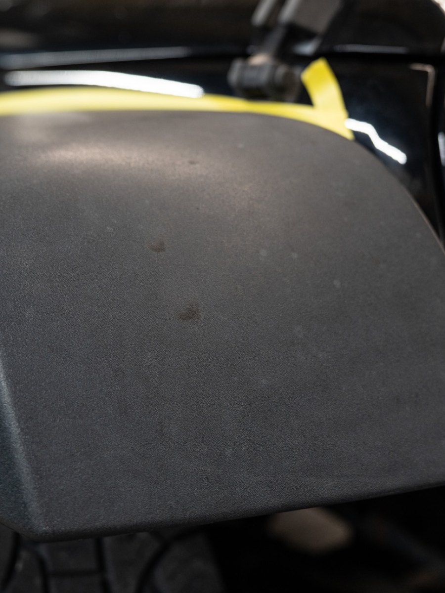 Faded Jeep fender flare restored to factory black, after