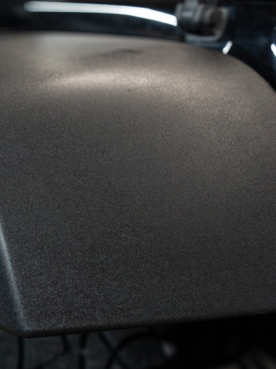 Faded Jeep fender flare restored to factory black, before
